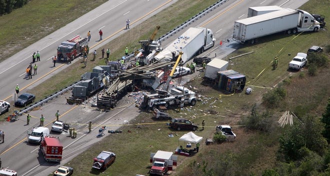Investigators work the scene of a multi-vehicle accident on the Florida Turnpike Tuesday near St. Cloud. The deadly 13-vehicle wreck killed at least five people and also involved a fire truck and sheriff's cruiser headed to an earlier crash, the highway patrol said.