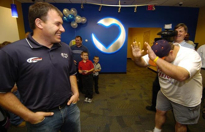 Nascar driver Ryan Newman laughs as store customer Kevin Wilson, of Belvedere, bows down to him inside the new Alltel outlet on Robert C. Daniel Parkway. Newman gave Wilson a trip to a NASCAR race in Texas.