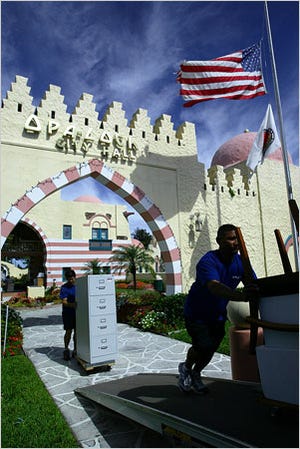 Movers taking furniture out of City Hall in Opa-locka, where the architecture runs to Moorish antiquity.