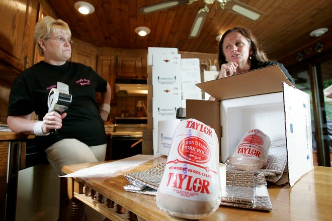 Pattie Weaver, left, and Donna Beers, partners in a mail-order business that sends Taylor Pork Roll to customers around the country, pose in a kitchen where they package pork rolls for shipping in Mansfield Township, N.J.