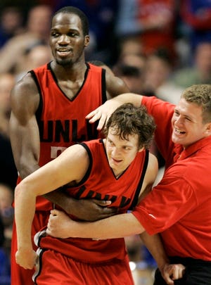 UNLV's Kevin Kruger, son of coach Lon Kruger, is congratulated by teammate Joel Anthony, left, and equipment manager Rocky Rutledge after their win Sunday in Chicago.