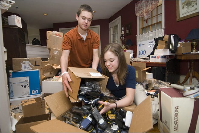 Robbie and Brittany Bergquist of Norwell, Mass., sorting used cellphones they will sell to a recycler.