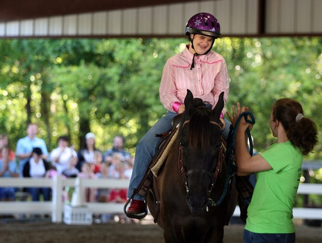 Mary Roberts smiles as volunteer Marissa Baisden claps. Roberts was the winner of the Western Equitation at the Special Olympics Equestrian Area Games.
