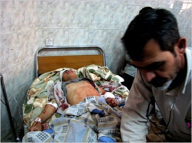 An Iraqi man with his son, who was wounded Saturday by a blast in Hilla. Bombs also hit two other cities.