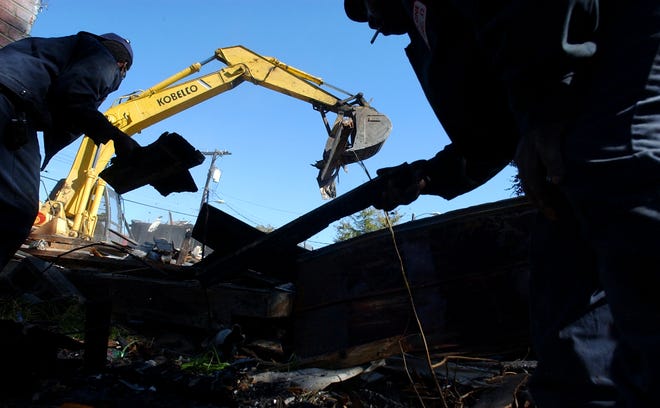 Contractors working for the city of Savannah demolish an abandoned home at 9 W. 58th St. on Friday. The structure had burned, and the owners gave the city permission to demolish it earlier this month. The owners will be billed $1,533.40 to pay for the demolition.  Hunter McRae/Savannah Morning News