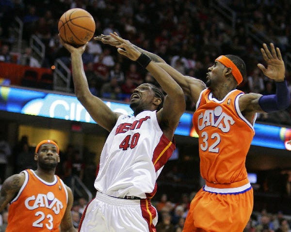 Miami Heat's Udonis Haslem (40) puts up a shot against Cleveland Cavaliers' Larry Hughes (32) as Cavaliers' LeBron James watches during the third quarter of an NBA basketball game Thursday, April 5, 2007, in Cleveland. Miami beat the Cavaliers 94-90 in overtime. (AP Photo/Mark Duncan)