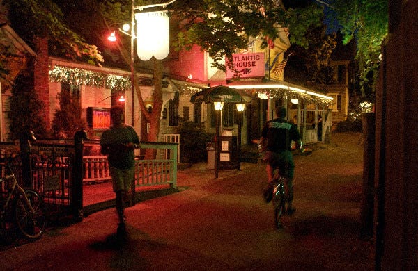 Passers-by in front of the Atlantic House restaurant and bar just off Commercial St. in Provincetown on a late-summer's eve. (dewitt photo 8/21/03)