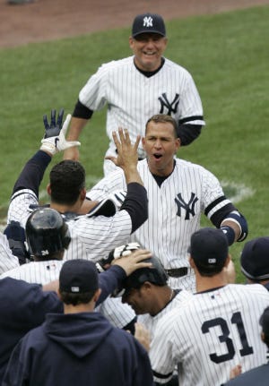 New York Yankees' Alex Rodriguez, center, is greeted at home plate by teammates after hitting a game-winning grand slam in the ninth inning of baseball action against the Baltimore Orioles Saturday, April 7, 2007 at Yankee Stadium in New York. The Yankees won the game 10-7. (AP Photo/Frank Franklin II)