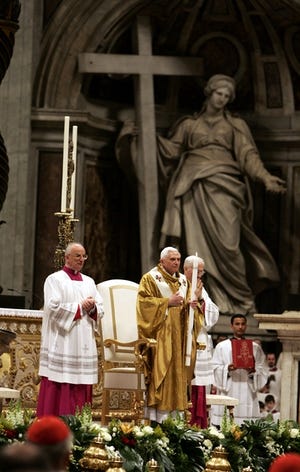 Pope Benedict XVI, center, holds a candle during the Easter Vigil ceremony in Saint Peter's Basilica at the Vatican on Saturday.