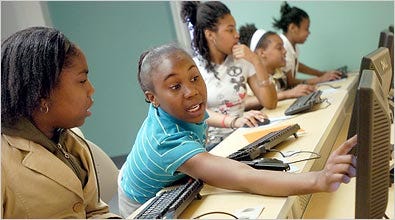 Tobi Carter, 11, and Taylor Street, 12, work with computers at the Dawson Safe Haven Center in Baltimore.