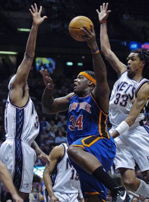 New York Knicks' Eddy Curry (34) goes up with a shot between New Jersey Nets' Jason Collins, left, and Mikki Moore, right, during first quarter NBA basketball Friday night, April 13, 2007, in East Rutherford, N.J. (AP Photo/Bill Kostroun)