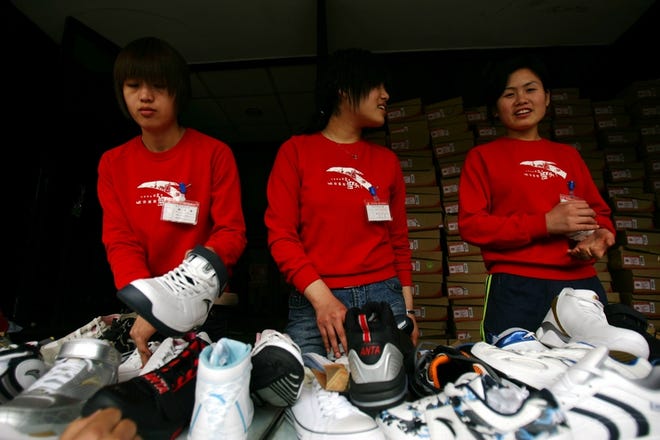 Attendants wait for customers at a shoe store in Beijing.