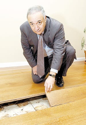 Louis Cioffi shows the damaged living room floor in his newly constructed home in Cornwall on Friday, April 13, 2007. The Cioffis are suing the contractors, architect and engineer who they say are responsible for building and selling them the house that became water logged when it rained, and caused extensive damage and causing both of them to develop health problems from mold and bacteria presence.