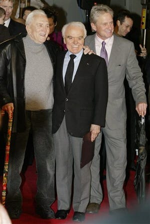 Jack Valenti, president emeritus of the Motion Picture Association of America, center, pauses for a photo with actors Kirk Douglas, left, and Michael Douglas after placing his hands and footprints in cement at Graumans Chinese Theatre, Monday, Dec. 6, 2004, in the Hollywood section of Los Angeles. Valenti, the former White House aide and movie industry lobbyist who created the modern ratings system and tirelessly championed Hollywood's interests for nearly four decades, died Thursday April 26, 2007. He was 85.