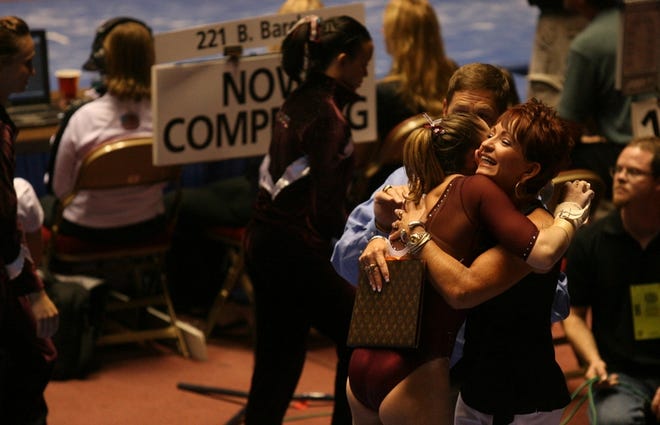 Alabama gymnastics coach Sarah Patterson, right, hugs gymnast Kassi Price after a routine during the opening day of competition at the NCAA Championships. Alabama finished fifth in the six-team session.