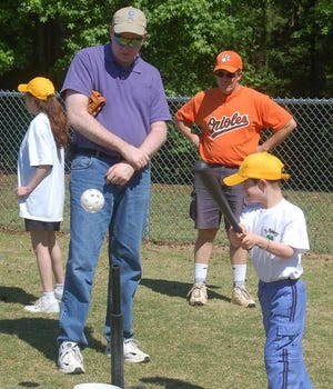 Randy Henning (left) watches his 8-year-old son, Matthew, a pupil at Brookwood Elementary School, hit a ball off a tee in a TRecS event at North Augusta's Riverview Park.