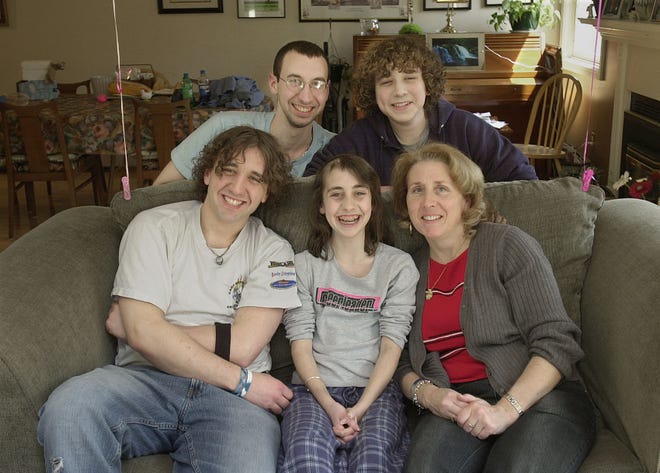 Casey Roach, center, sits with her family at home in Medway last week. From left are brothers, Adam, 20, Justin, 23, Eric, 16, and mother, Cathy.