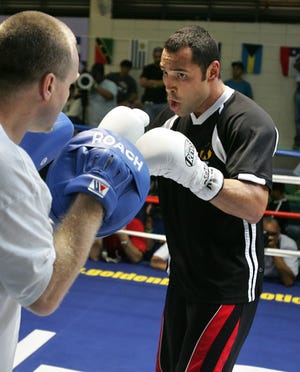 **FILE** U.S. boxer Oscar De La Hoya, right, works out with his trainer Freddie Roach, during a training event in Guaynabo, Puerto Rico, in this April 11, 2007 file photo. De La Hoya, who will fight Floyd Mayweather Jr. in Las Vegas on May 5, is part of "De La Hoya/Mayweather 24/7," HBO's new reality show. (AP Photo/Brennan Linsley, File)