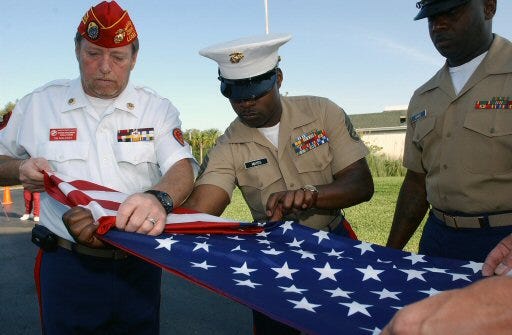 The American Flag that was flown in Iraq now flies at The Cascades on Silver Springs Boulevard in Ocala. From left to right, Tim Maloney of Marion County, former commandant, Staff Sgt. Frederick Mayes and Staff Sgt. Tommie Hugee fold the flag during the ceremony.