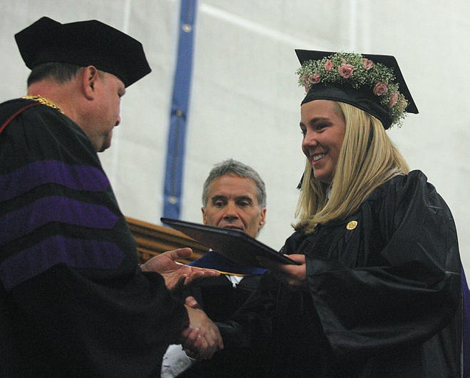 Stonehill College President Mark Cregan presents a diploma to Kendra Kucera of Troy, New york at the 56th Commencement Exercises.