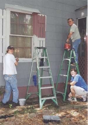 Ben Beasley, Paul Hammond (on ladder), and John Casteel tackle a house-painting project on 36th Street.