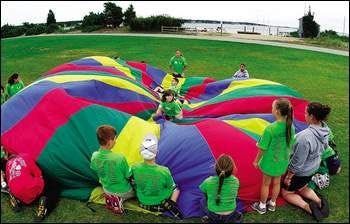 Children from Camp Angel Wings play with a parachute during activities at YMCA Camp Massasoit in Mattapoisett. The children were part of a bereavement camp for kids ages 5 to 17 sponsored by Southcoast Home Care Hospice.
