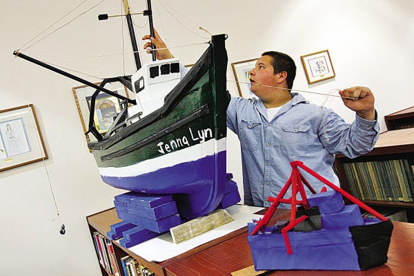 PETER PEREIRA/The Standard-Times
Frank Tomkiewicz III adjusts the outriggers on the model of the Jenna Lyn he made with the help of his father as part of a project for school. The model is on display in the library of the Ford Middle School in Acushnet, where Frank attends school.