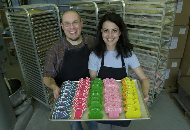 Fancypants Bakery owners Justin Housman and Maura Duggan hold a tray of their hand-decorated cookies at their bakery in Walpole.
