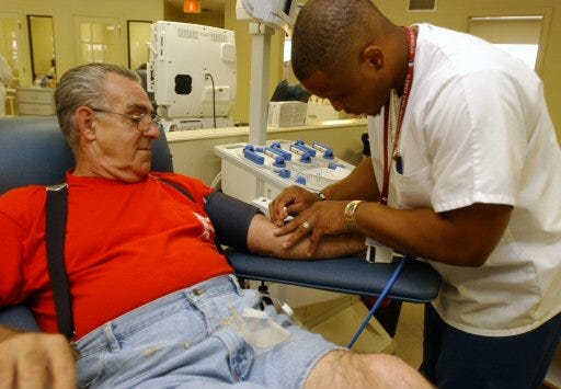 Volunteer Terry Pafford is donating blood. Here Cory Freeman readies Mr. Pafford for the procedure. . ####dorothy johnston/for the star banner /2007