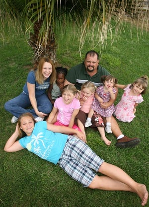 John Luzader poses with children, from left, Krystall, 12; Amber, 20; Myrikal, 3; Krysten, 9; Kira Cook, 4; Krystina, 2; and Kiana, 4, near Silver Springs Shores.