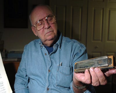 Monroe Heide shows off one of his harmonicas in his house in Stillwater Lakes Wednesday.