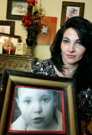 Rachel Clemens poses with a photograph of her daughter, Adrianna Clemens, at her home in Richardson, Texas, May 29.