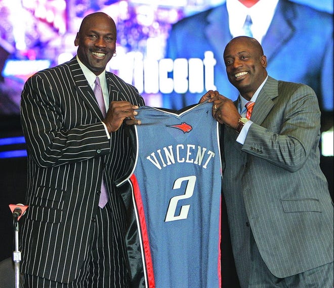 Charlotte Bobcats new head coach Sam Vincent, right, holds a jersey with part-owner of the team Michael Jordan, left, during a news conference in Charlotte, N.C., Friday, May 25, 2007. (AP Photo/Chuck Burton)
