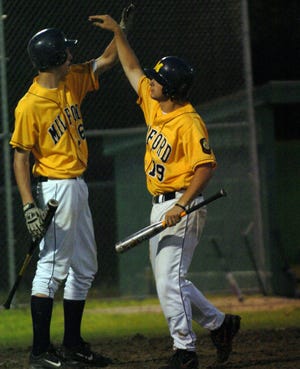Milford's Mark Claffey (right) is congratulated by Mark Shaddock after scoring the first run against Clinton.