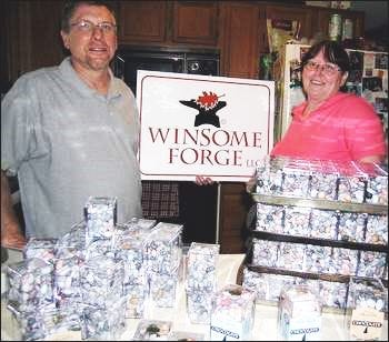 Krauss/Democrat photo
Richard and Bette Jo Menzel, owners of Winsome Forge LLC, stand in their kitchen, behind dozens of chocolate-filled cubes bound for destinations near and far.