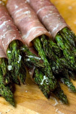 Don't limit your grilling to the entree. Try grilled asparagus wrapped in prosciutto. (AP Photo/Larry Crowe)
