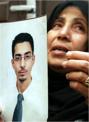 The mother of Mohammed Asha, arrested in connection with the terrorism plots in Britain, held a picture of her son in Jordan on Monday.