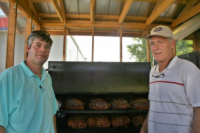 Kevin Fabre, left, and his father Clyde Fabre stand in the smokehouse behind their Richmond Hill barbecue restaurant, The Smokin' Pig.