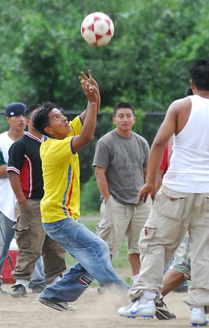 Ecuadorean immigrants play volleyball after a day of work at Fino Field in Milford.