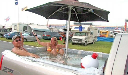 Fred and Sherry Pinkerton of Astor ride in the "Bubba tub" that they and some friends made from a plastic drop cloth and duct tape at the Daytona International Speedway's infield on Saturday, prior to the Pepsi 400.