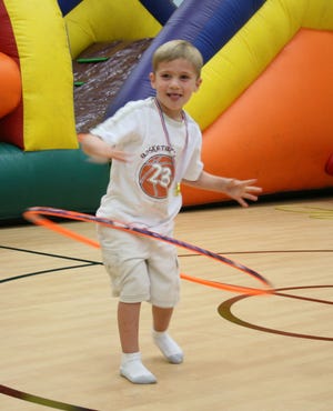 Trip Vorel of Rincon tries his luck with the hula hoop while participating in the "healthy kids" activities at the new YMCA's grand opening.