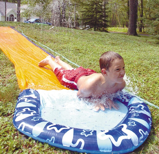 Matthew Vigorito, 9, of Middle Smithfield Township beats the heat by splashing down his new Slip n' Slide with his sister, Carly, 11.