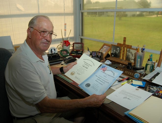 Carl Ayers shows two of his many certificates of appreciation from various military organizations.