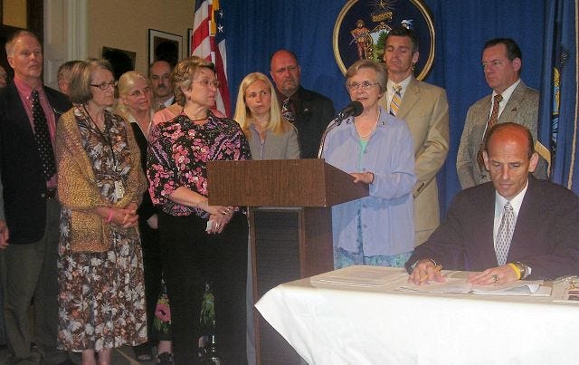 State Rep. Joan Nass, R, Acton, second from left, and a number of other legislators listen as Barbara Damon-Day speaks about her son, Capt. Patrick Damon, who died in Afghanistan last year. Governor John Baldacci signed into law a bill, championed by Damon-Day, to ensure better health screening for Maine soldiers.