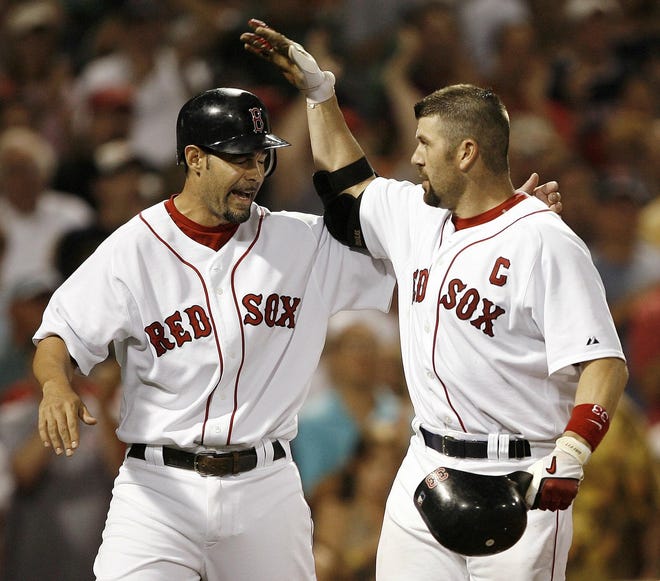 Mike Lowell congratulates Jason Varitek (right) after the Red Sox catcher hit a two-run, go-ahead homer.