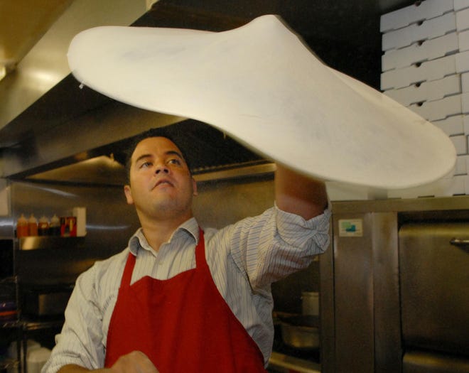 Zack Chaves, the owner of Superior Pie in Framingham, tosses dough for a pizza.