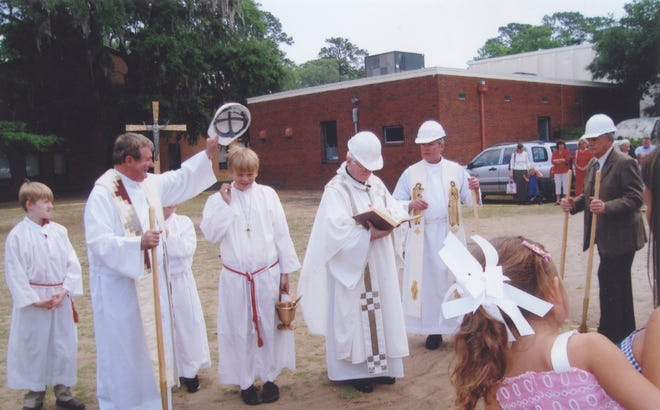 The Rev. Patrick O'Brien tips his hard hat as the Most Rev. J. Kevin Boland, bishop of the Diocese of Savannah, officiates at the parish center groundbreaking.