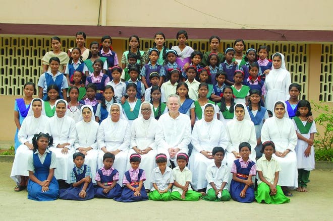Paul Wilkes (second row, sixth from left) sits with the girls in a Catholic orphanage in India. Wilkes first saw the orphanage for runaway girls while on vacation with his wife, and he was so inspired that he returned a few days later to make a documentary.
