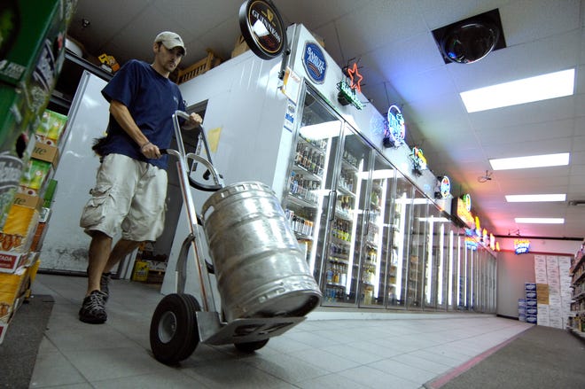 Stock clerk Michael Cillo wheels a keg of beer from the cooler at Habersham Beverage Warehouse on Abercorn Street.
