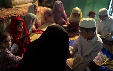 Hameeda Sarfraz, in the dark burqa, teaches Islamic religious lessons to children in her village, about 50 miles north of Islamabad, Pakistan.
